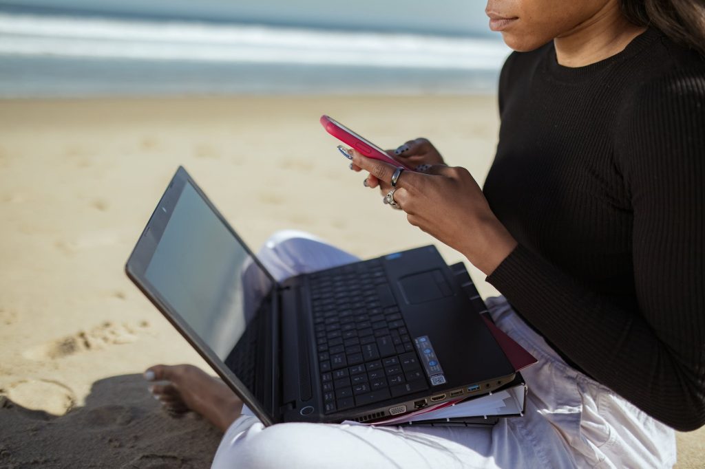 woman in black long sleeve shirt using black laptop computer. Suggests that you can get a digital nomad visa in Brazil